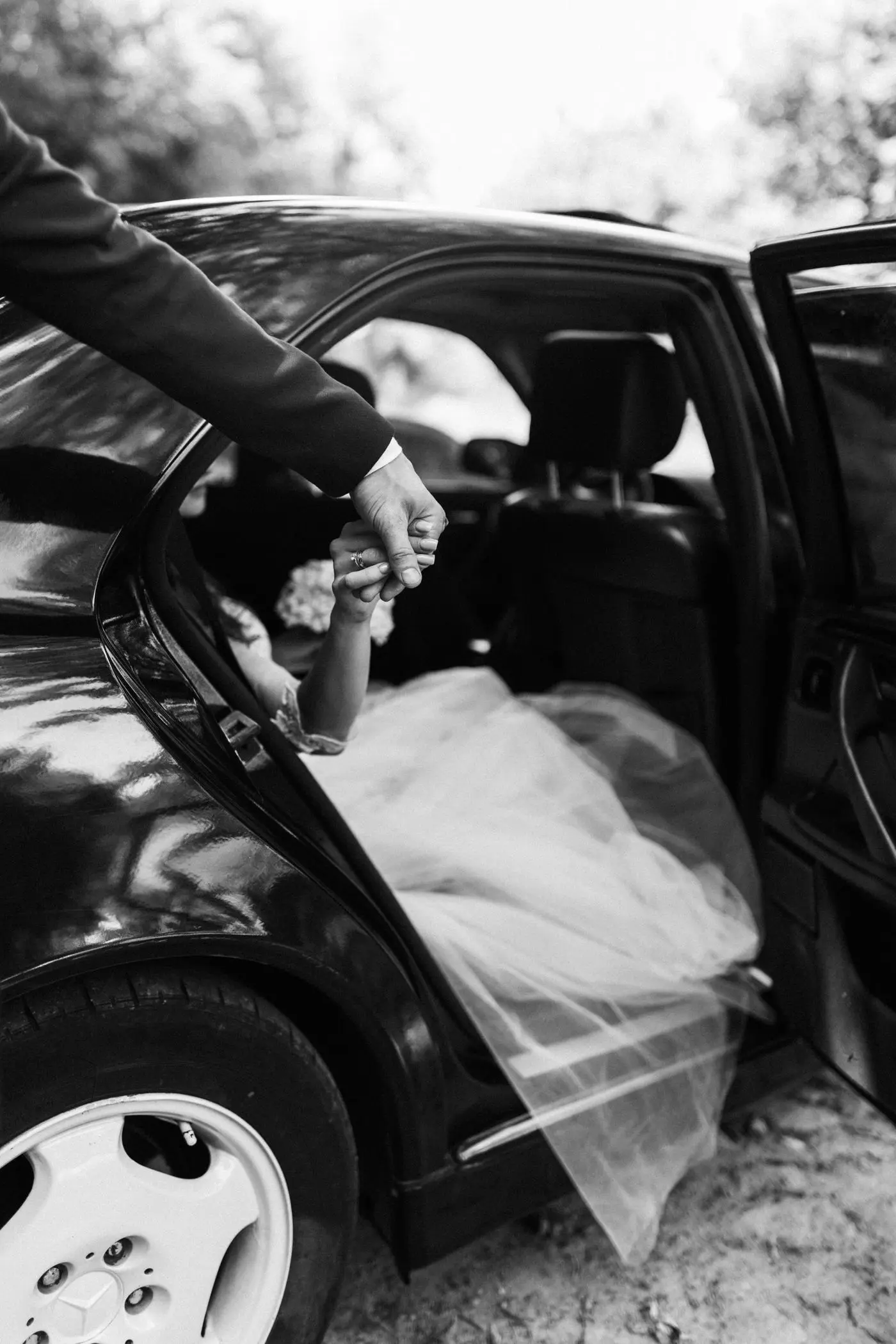 Bruid stapt uit de auto bij de trouwlocatie
