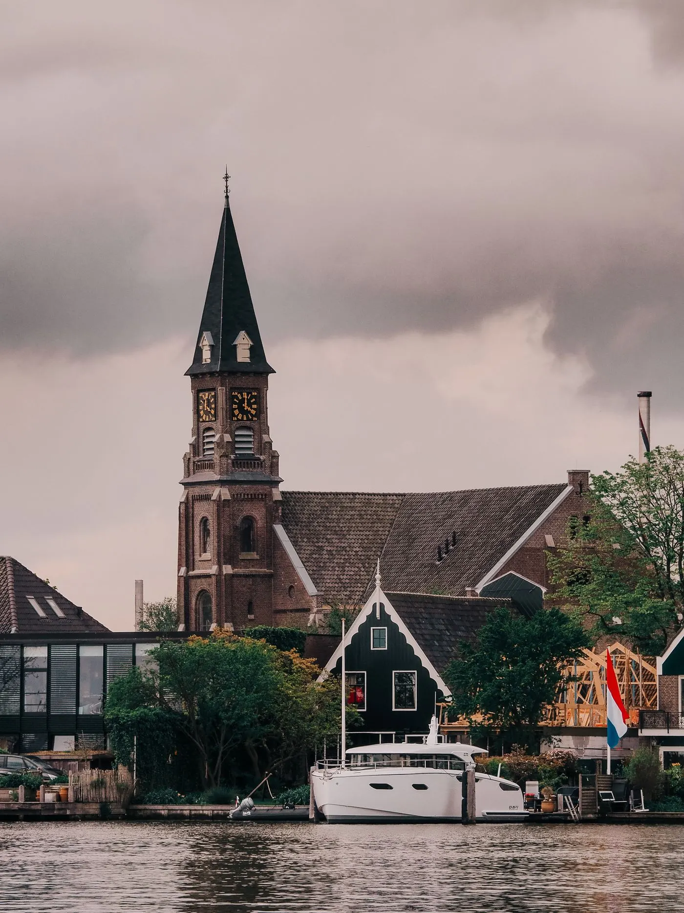 Kerktoren en botter aan het water in een Nederlands vissersdorp