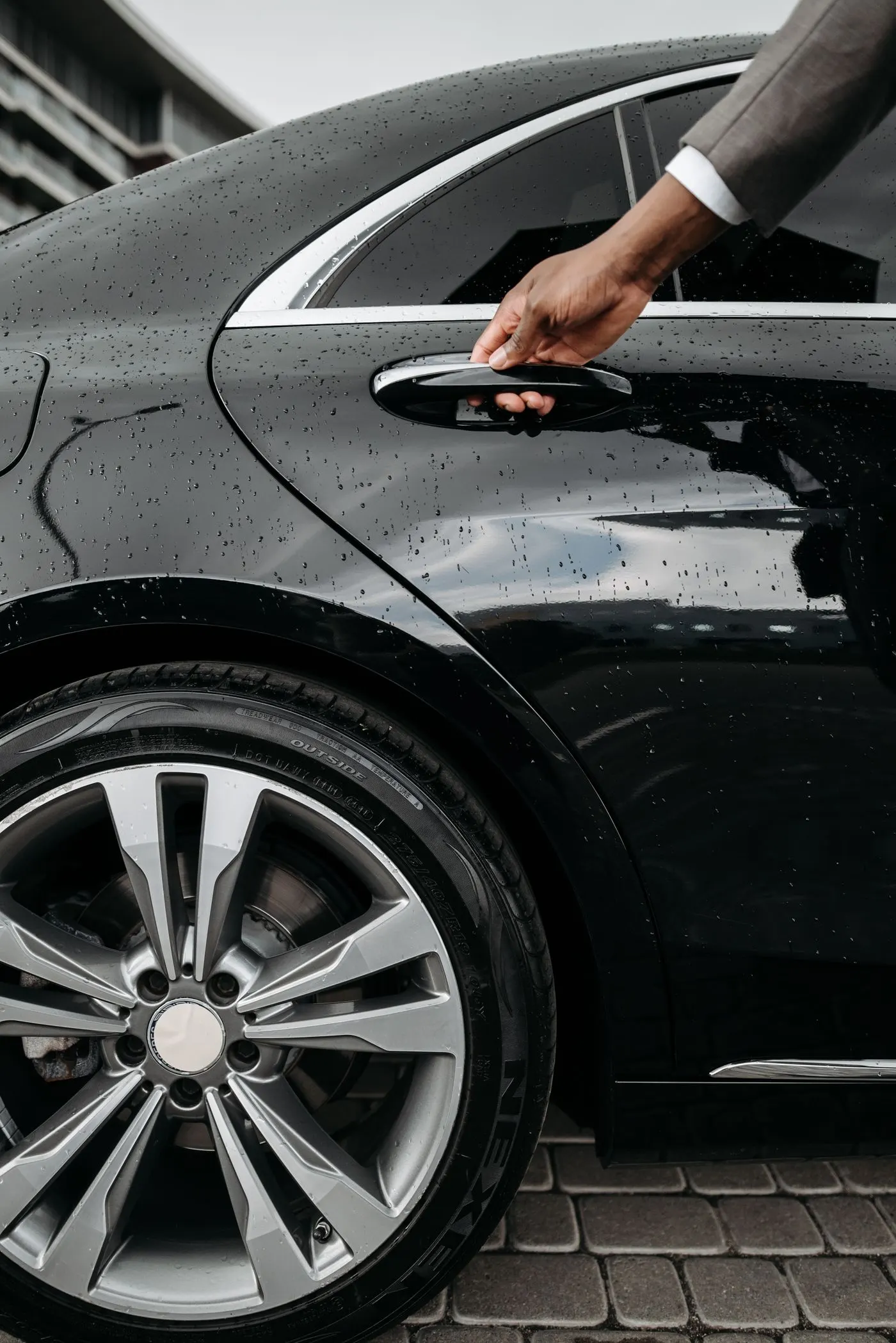 Chauffeur opent het achterportier van een taxi voor een passagier