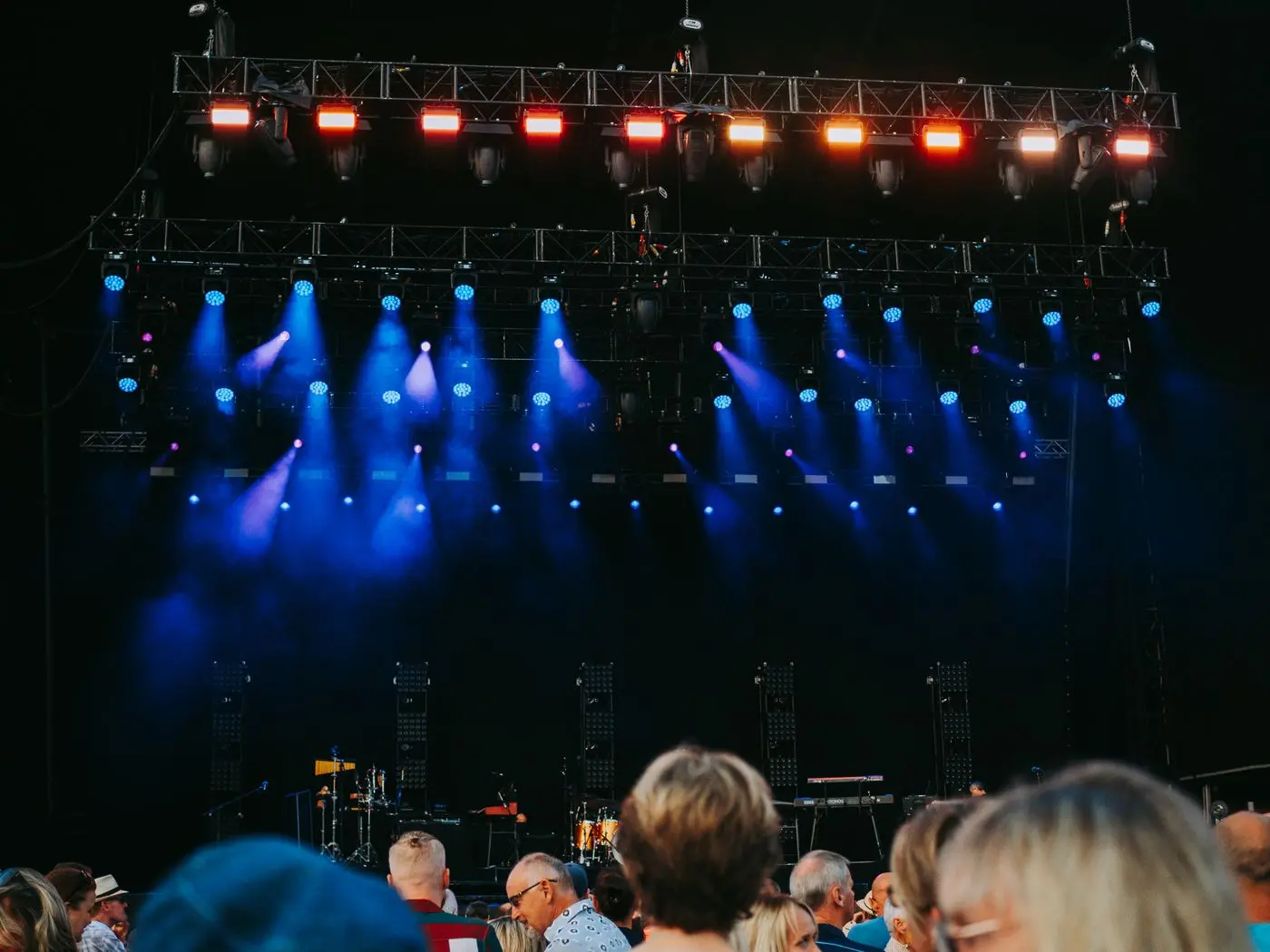 Publiek bij een avondconcert met gekleurde podiumlichten