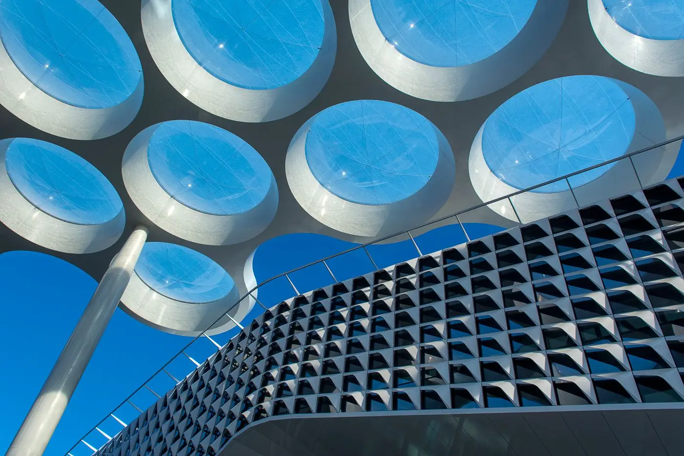 Het golvende dak van Utrecht Centraal onder een blauwe lucht